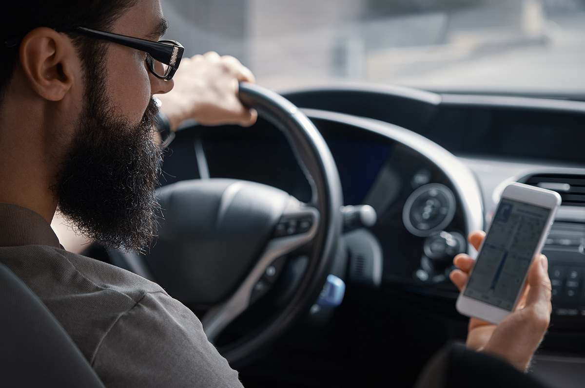 Photo of two people in a car using a mobile Google search to find a local business.